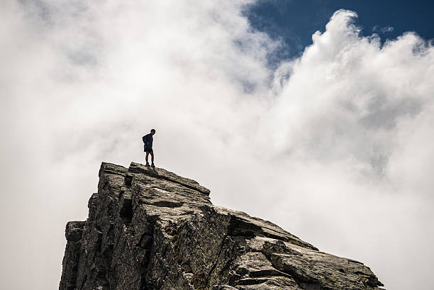 istock Hiker standing high up on rocky mountain peak 476864888