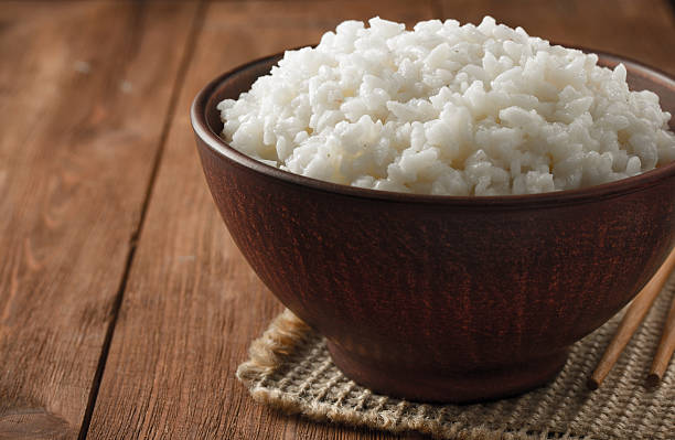 istock bowl full of rice on wood 476866530