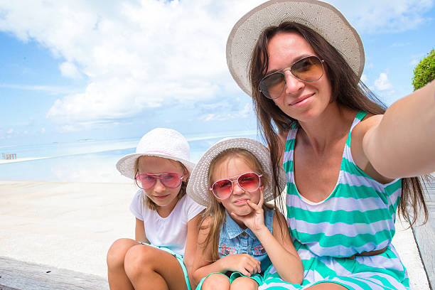 istock happy family taking selfie at tropical beach 476869954