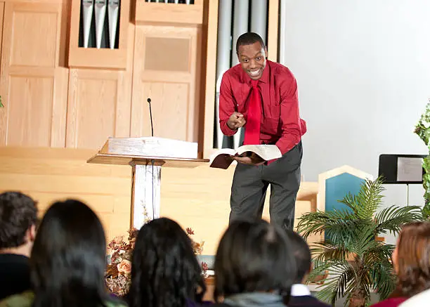 A group of people listening to a sermon in church.