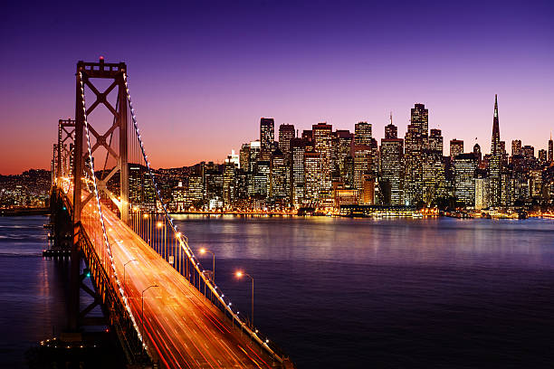 Bay Bridge and San Francisco skyline at sunset San Francisco skyline and Bay Bridge at sunset, California san francisco california stock pictures, royalty-free photos & images