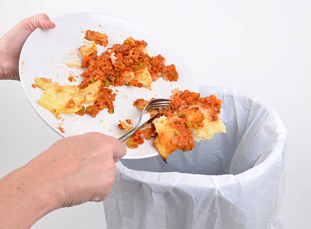 Removing food into a bin Scraping food from a plate scraping stock pictures, royalty-free photos & images