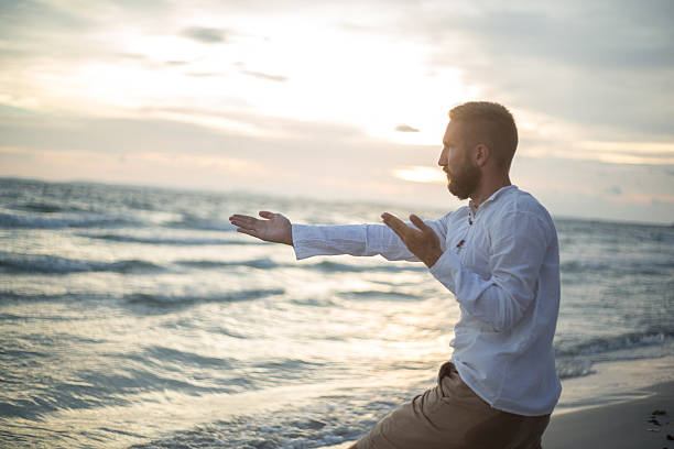 tai chi e yoga posizione sulla spiaggia al tramonto - sunset yoga young men caucasian foto e immagini stock