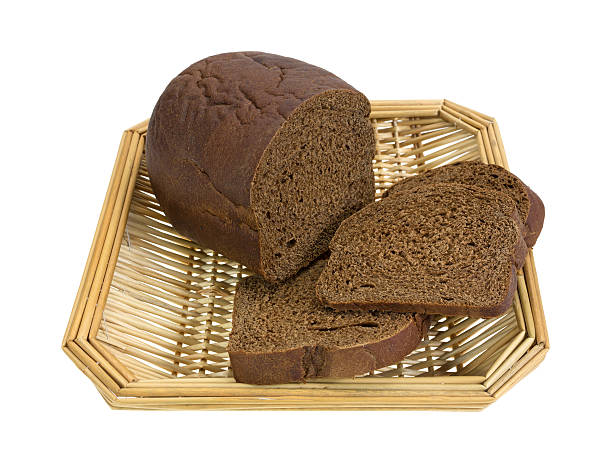 frische pumpernickel brot in wicker basket - pumpernickel stock-fotos und bilder