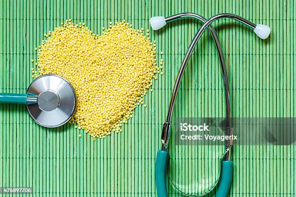 Millet Groats Heart Shaped On Green Mat Surface Stock Photo - Download Image Now - 2015, Alkaline, Cardiologist