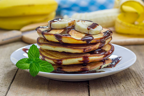 istock Stack of pancakes with banana and chocolate syrup 476907090