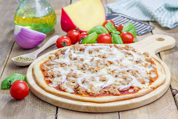 pizza com atum, peixe em uma tábua de madeira - pizza onion close up italian culture - fotografias e filmes do acervo