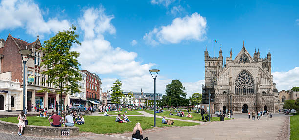 Exeter, United Kingdom - May 26, 2015: Tourists and pedestrians relaxing in the gardens around Exeter Cathedral grounds. Exeter Cathedral is an Anglican cathedral dating back to 1050.