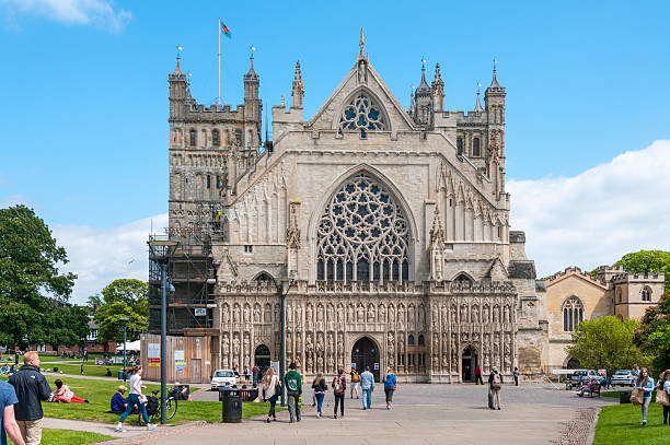 Exeter, United Kingdom - May 26, 2015: Tourists and pedestrians walking around Exeter Cathedral grounds. Exeter Cathedral is an Anglican cathedral dating back to 1050.