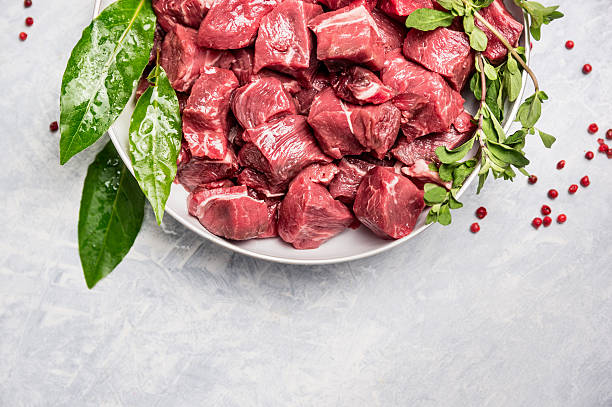 Chopped raw beef meat in white bowl with fresh herbs