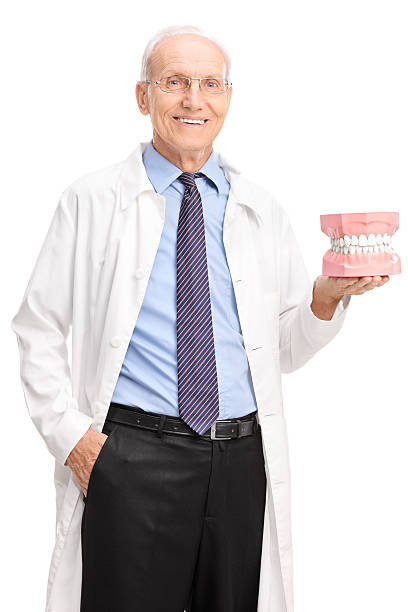 istock Vertical shot of mature dentist holding a denture 476911792