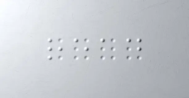 A closeup concept of a set of four isolated braille letters spelling out the word read on a textured white paper