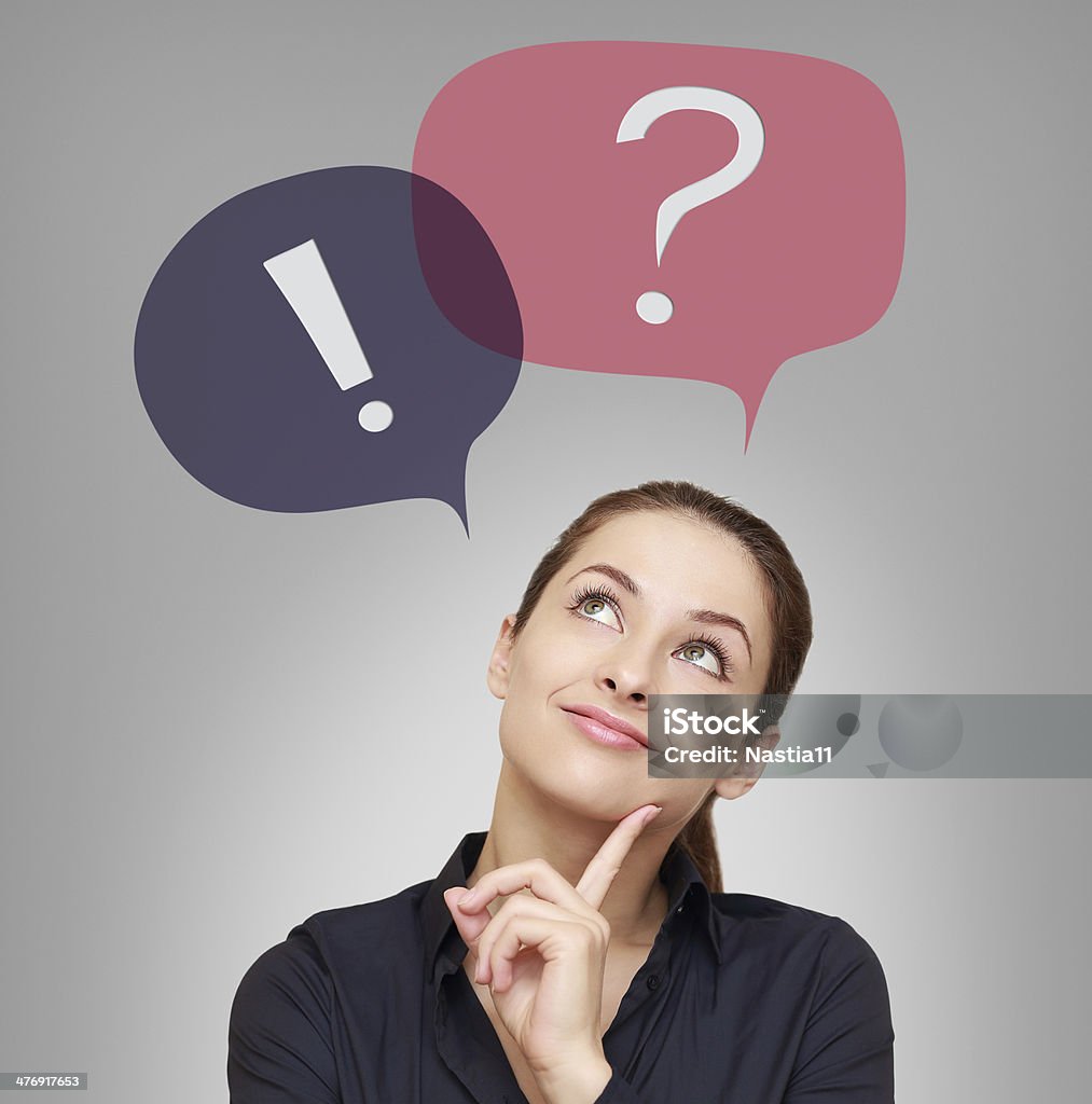 Thinking woman looking on question and exclamation above Thinking woman looking on question and exclamation above on grey background Exclamation Point Stock Photo