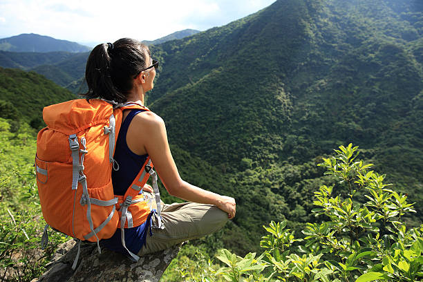 istock woman backpacker enjoy the view at mountain peak cliff 476918010