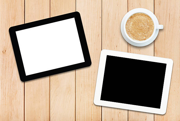 istock Two tablet PCs and coffee on a wooden table 476918354
