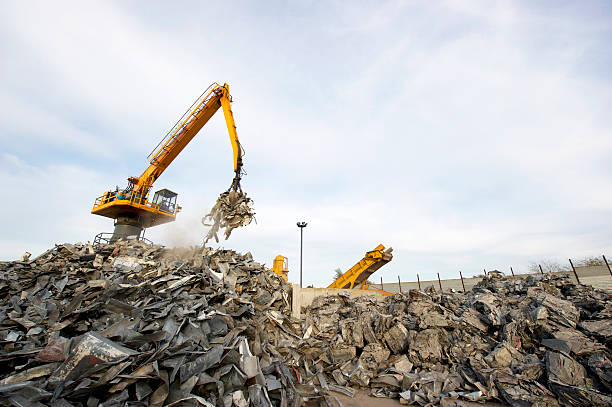 Scrap metal recycling plant and crane Scrap metal recycling plant and crane-Loading scrap in a truck junkyard photos stock pictures, royalty-free photos & images