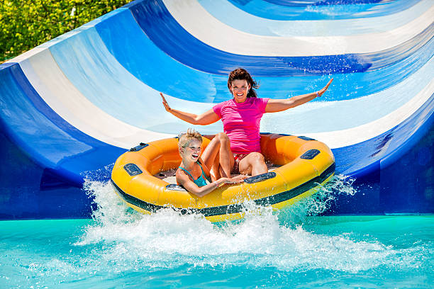 hijo y madre en el tobogán acuático en aquapark - park and ride fotografías e imágenes de stock