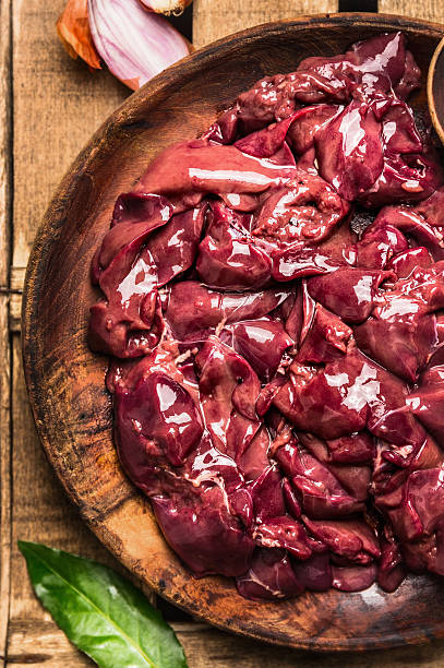 Raw chicken liver in wooden bowl ready for cooking stock photo