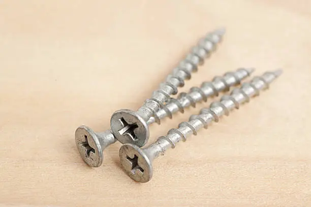 Screws on a wood background. Shot in studio with Canon 5D Mark II DSLR camera.