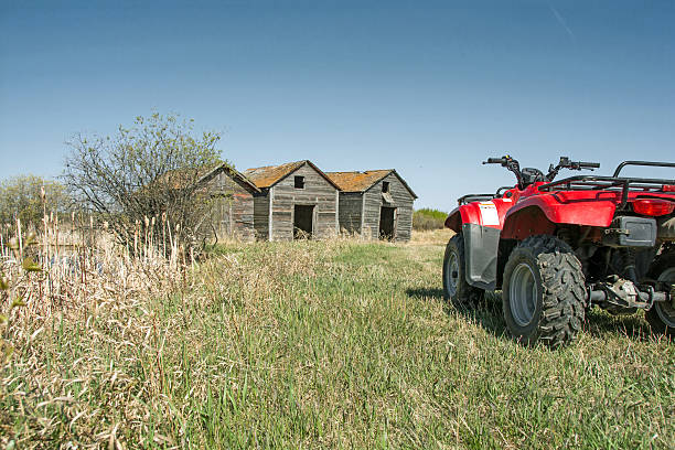 istock Farm with old wood graineries and red atv- sping time 476929296