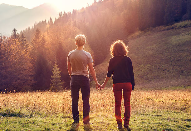 istock Young couple takes hands in sunset time 476938900