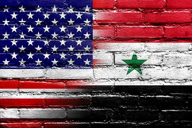 istock USA and Syria Flag painted on brick wall 476943295