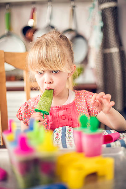 istock Cute Little Girl Eating Popsicles 476944082