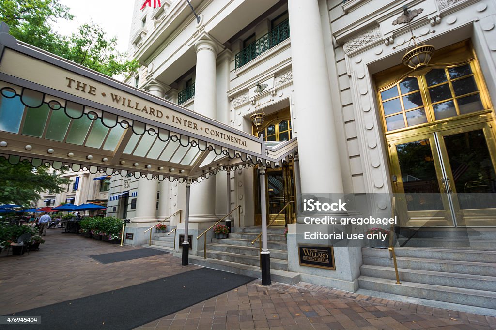 Entrance to Willard InterContinental Washington in District of Columbia Washington, United States - August 19, 2014: People meander about the sidewalk outside The Willard InterContinental Washington, a Beaux-Arts hotel located at 1401 Pennsylvania NW, during the daytime while other people meander about further down the sidewalk. It is situated two blocks east of the White House. Hotel Stock Photo