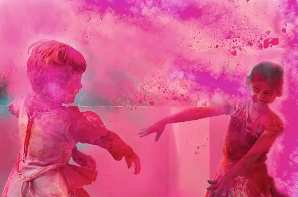 Photo of Two little kids playing with gulal on holi.