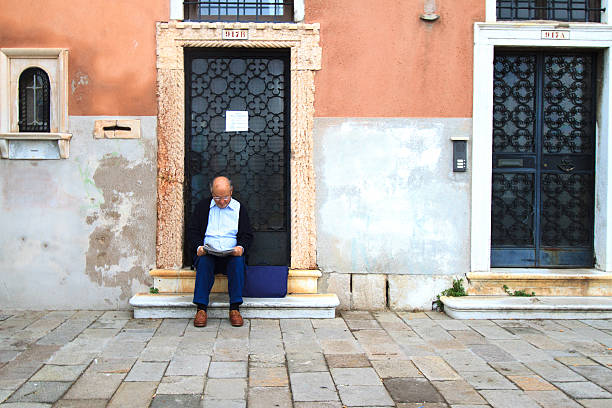 âgé lisant le journal sur le perron, venise, italie - front stoop photos et images de collection