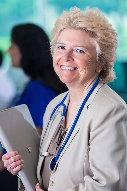 senior arzt oder hospital administrator lächeln während healthcare-konferenz - adminstrator stock-fotos und bilder