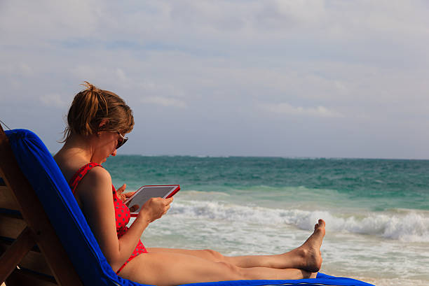 istock woman with touch pad on summer beach 476953042