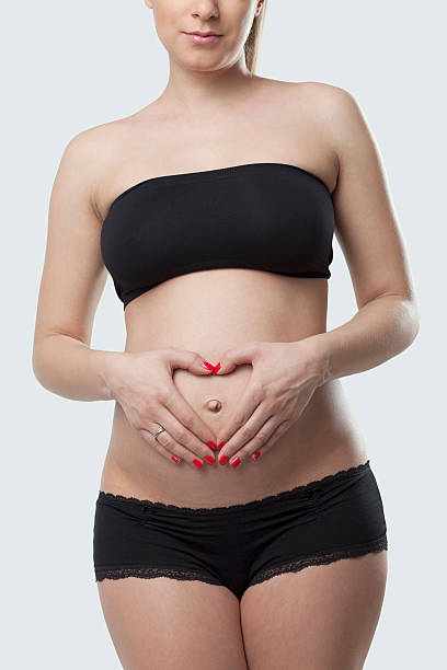 istock Woman holding her pregnant belly. White background. 476959549