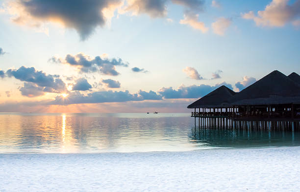 istock Sunset behind the clouds, silhouette of huts at the beach 476963914