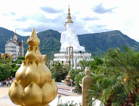 Phetchabun, thailand - June 2, 2015: view of 5 white buddha statue with the biggest one wearing the golden crown from the golden lotus pole at Pratart Pasonkaew temple at Phetchabun, thailand on June 2, 2015.