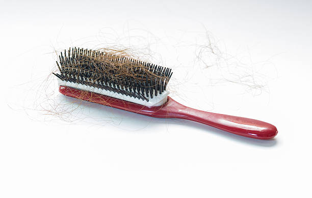 istock Hair fall on a red comb isolated on white background 476968974