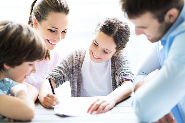 istock Family doing homework together at table 476971884