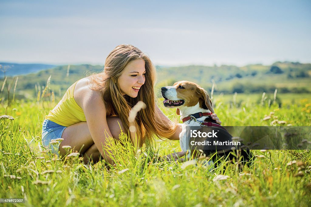 Teenager with her dog Lifestyle photo of happy young girl with her pet (beagle dog) - outdoor in nature Activity Stock Photo