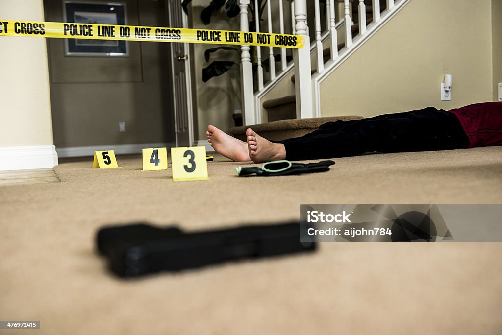 Crime scene A crime scene with a body and gun with yellow number markers. Barricade Tape Stock Photo