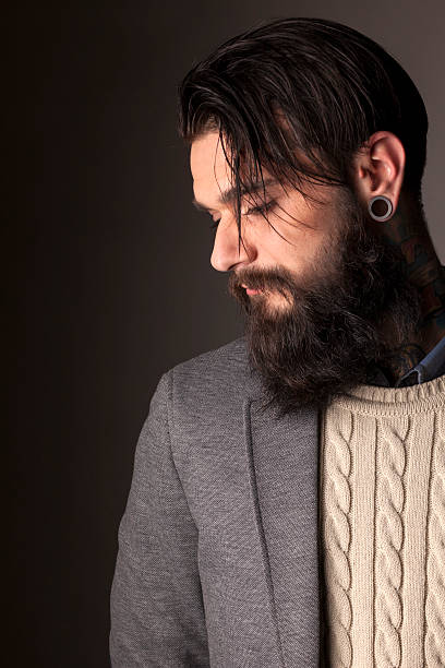 beard and tatoos young man with long beard and tatoos posing in the studio Earlobe stock pictures, royalty-free photos & images