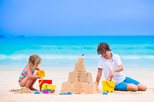 huppy kinder-gebäude sand-burg am strand - lifestyles child beach digging stock-fotos und bilder