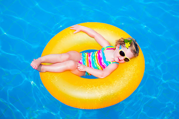 divertente bambina in piscina con salvagente gonfiabile - inflatable ring foto e immagini stock