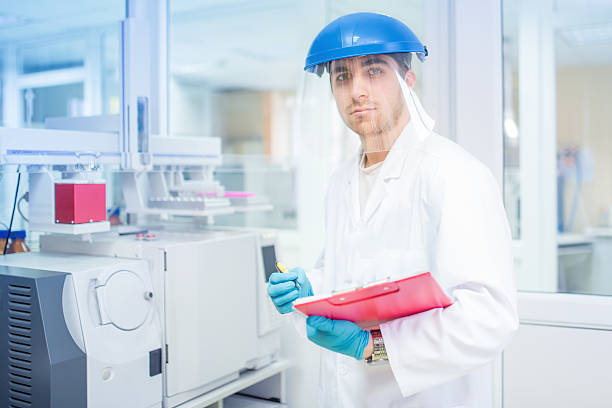 wissenschaftler mit schützenden gummi-handschuhe und helm auf und experimente - technitian stock-fotos und bilder