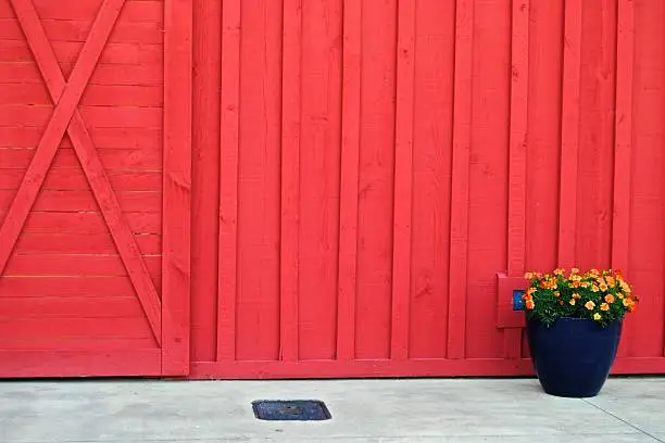 Bold red barn doors accompanied by a flowerpot