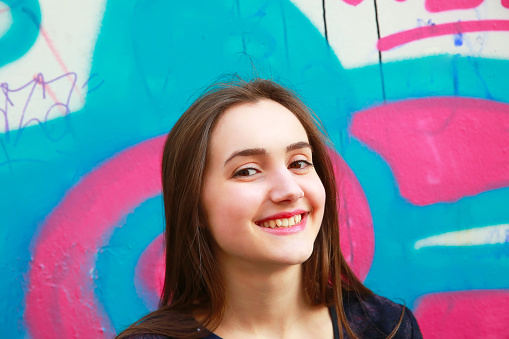 Portrait of beautiful girl on the colorful wall background