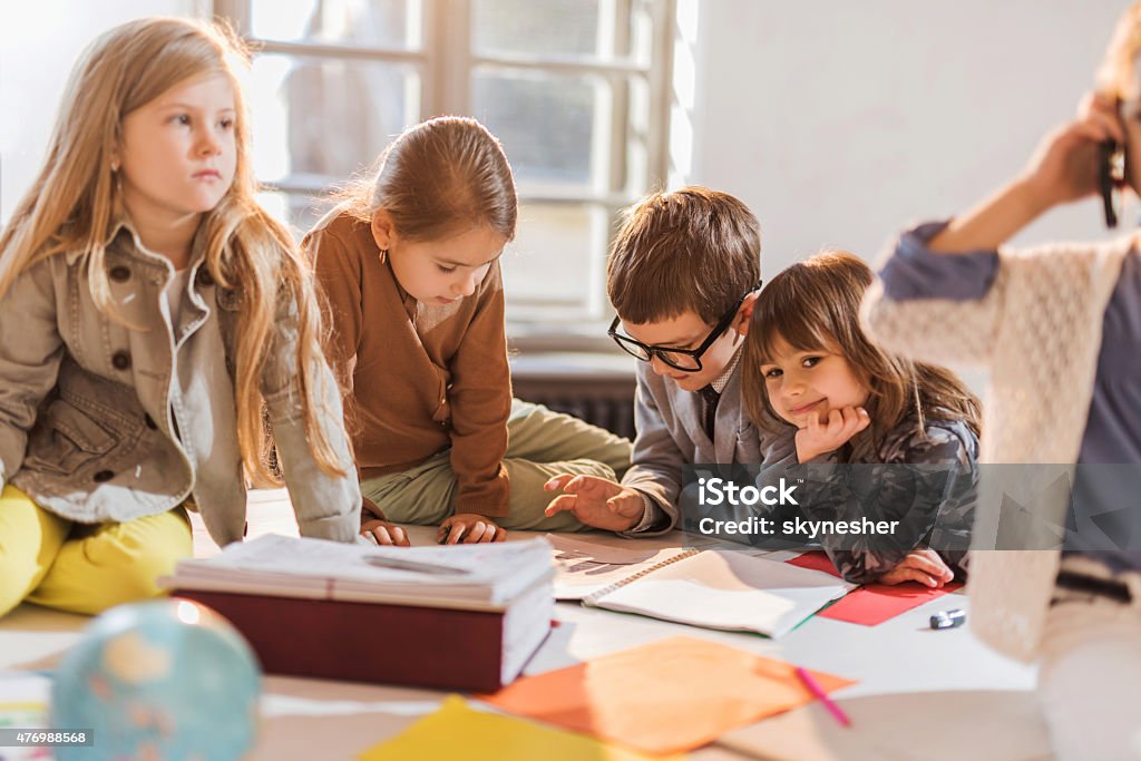Reading Paperworkids Group Of Creative Children Reading Documents Together Stock Photo ...