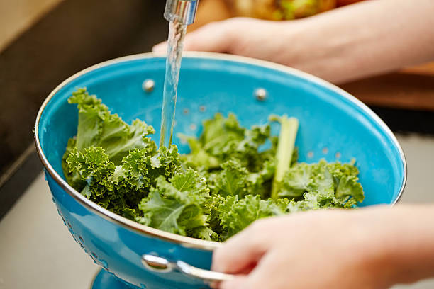 istock Woman washing kale in colander 476988954