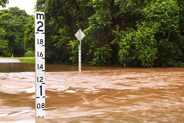 A flooded road with depth indicators in Queensland, Australia