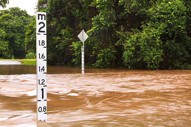 estrada inundada com profundidade indicadores em queensland, austrália - queensland imagens e fotografias de stock