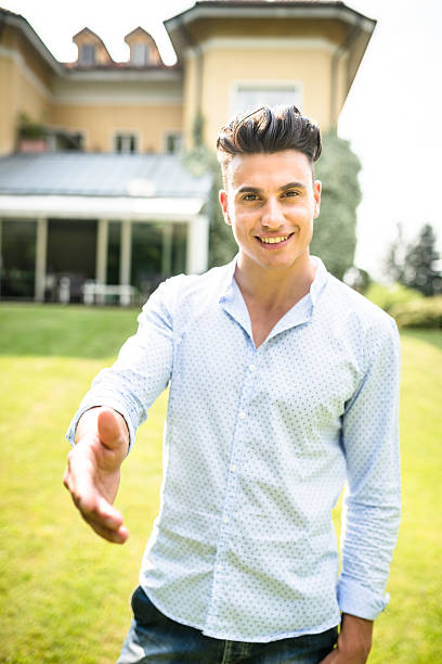 istock Owner in front of his villa showing it 476992896